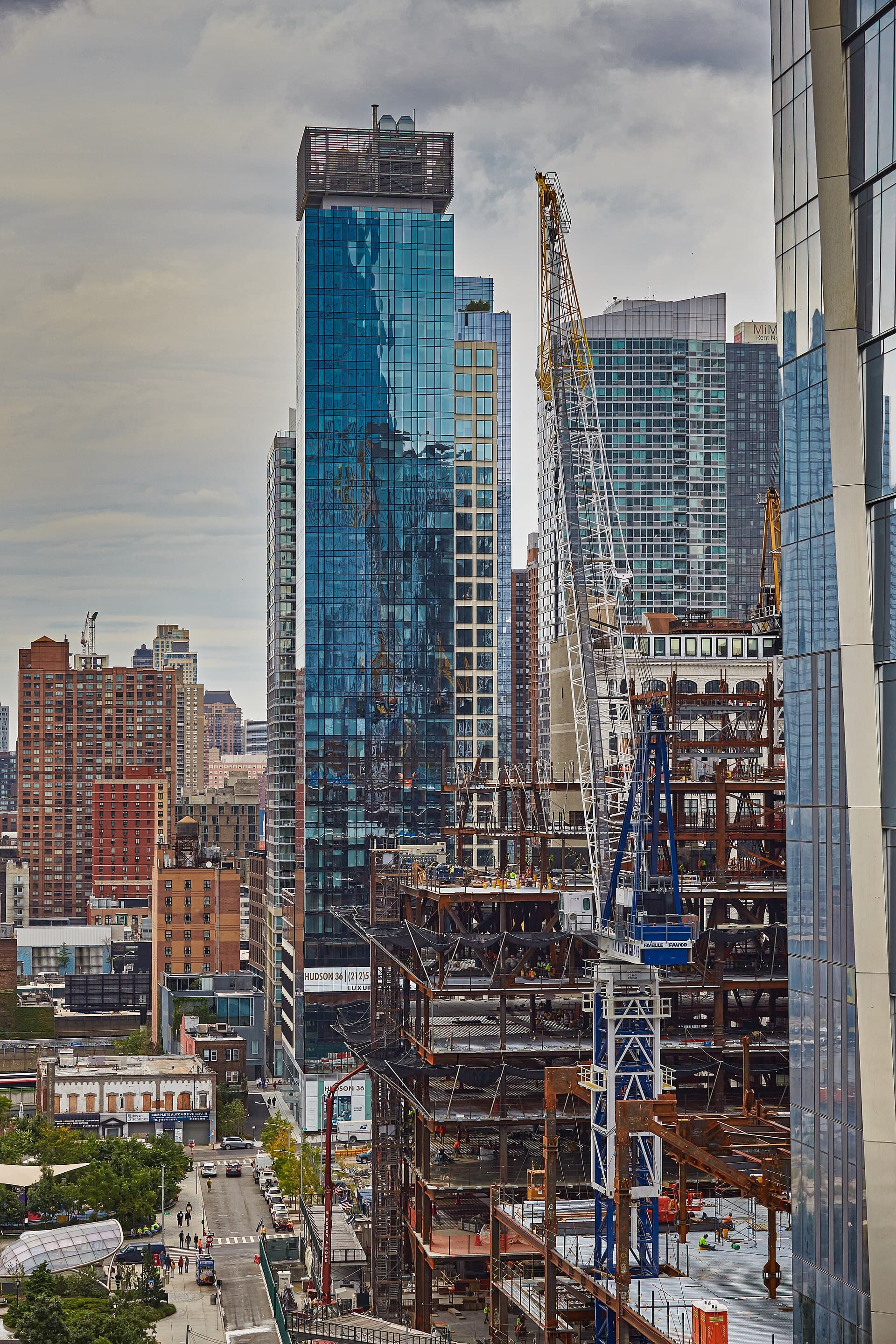 High-rise construction site with cranes and steel structure